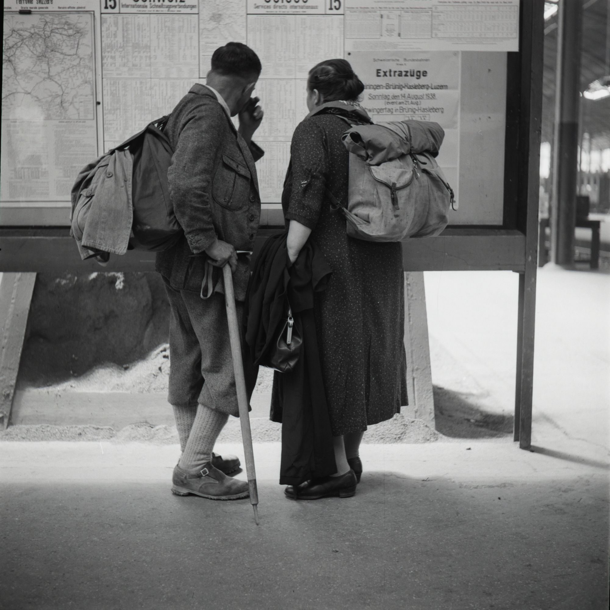 Picture from the SGV_12 Collection Showing Walkers Looking at the Timetable Train. Lucerne, 1938. Ernst Brunner. SGV_12N_00716. CAS. CC BY-NC 4.0